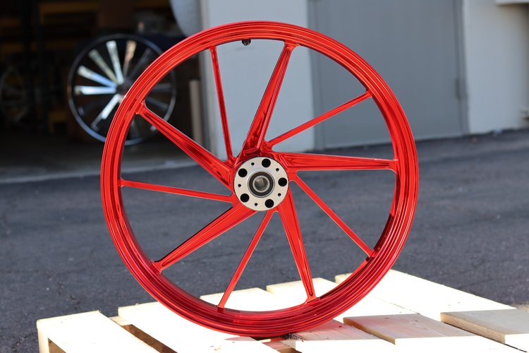 Red motorcycle wheel on a wooden pallet with a blurred background